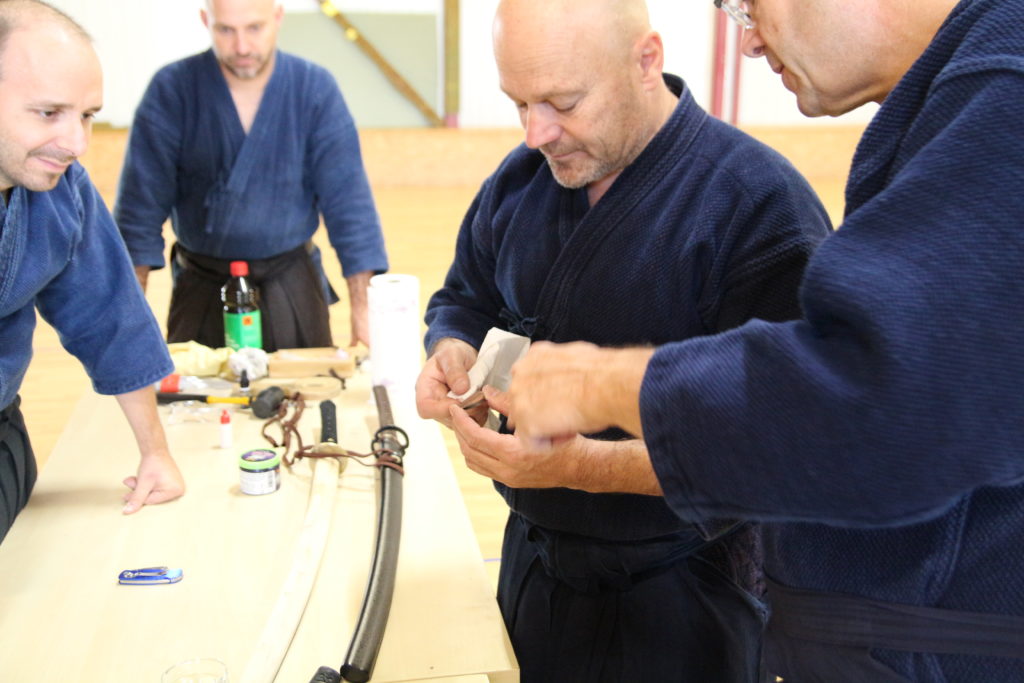 Atelier de montage de sabre japonais au Dojo Tanren en Valais, où les participants apprennent l’assemblage traditionnel du katana avec précision et respect des techniques ancestrales.